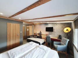 Ein Hotelzimmer mit Bett, Schreibtisch mit Stuhl, Fernseher und Lampe.