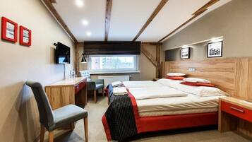 Un dormitorio con cama, escritorio, silla y ventana.
