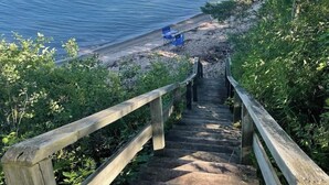 A wooden staircase leading to a beach with a view of the ocean.