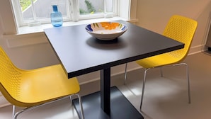 Ein kleiner Essbereich mit einem Tisch und zwei gelben Stühlen.