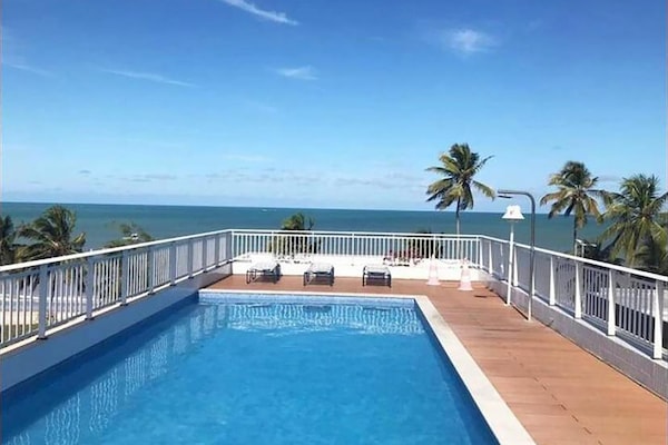 Una piscina al aire libre, sillones reclinables de piscina