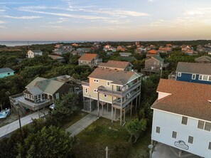 A coastal residential area with houses, some with decks and balconies, surrounded by greenery and a view of the ocean. - Oceanside, Steps to the Beach, Hot Tub, Pet Friendly, Ocean and Sound Views (Frisco)