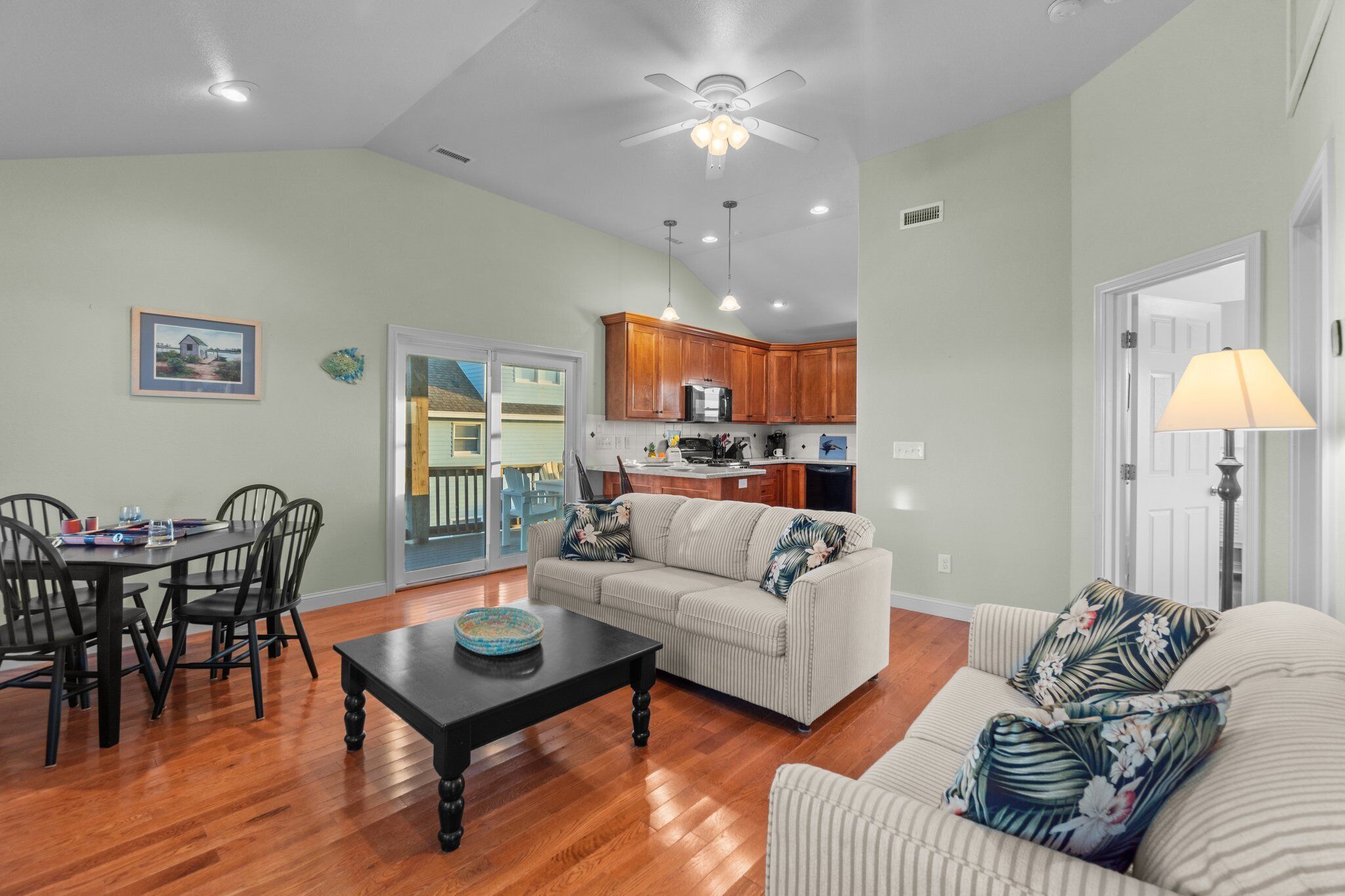 A living room with a sofa, coffee table, and dining area with chairs.