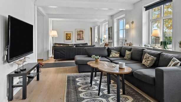 A modern living room with a sectional sofa, a flat-screen TV, and a coffee table. - 5 bedroom lovely home in Aakirkeby (Aakirkeby)