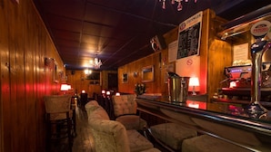 Eine Bar mit Holzwänden, einer Theke und Sitzgelegenheiten.