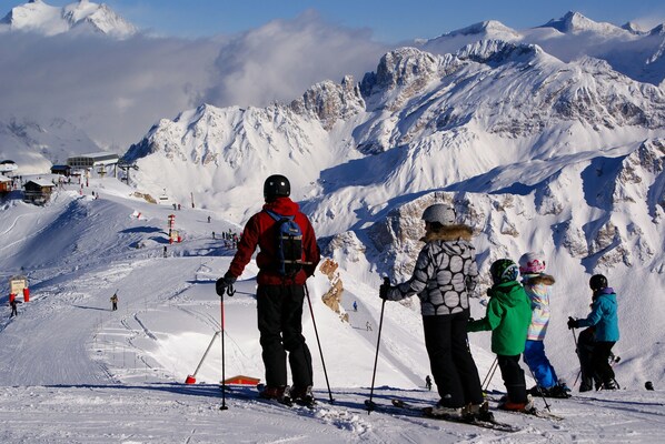 A snowy mountain slope with skiers and a ski lift. - Chambre pour 3 proche des Pistes! (Courchevel)