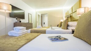 Een hotelkamer met twee bedden, een televisie, een bureau en een badkamer.