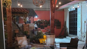 Un intérieur chaleureux avec des poutres en bois, des luminaires suspendus et des meubles en osier.