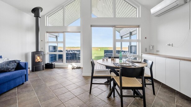 A modern interior with a fireplace, a dining area with a view, and a blue sofa. - Gorgeous home in Mesinge with WiFi (Mesinge)
