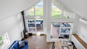A spacious living area with a large fireplace, a blue sofa, and a dining table set for four. - Gorgeous home in Mesinge with WiFi (Mesinge)