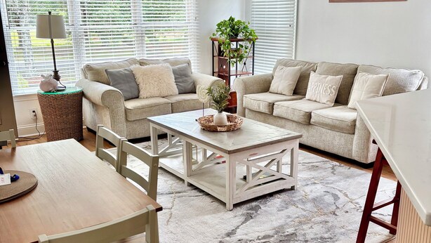 A living room with a sofa, coffee table, and dining table.