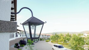 A residential area with a white car parked in the driveway, a black street lamp, and a clear sky. - Beautiful Modern Home in Res San Andres  (San Miguel)
