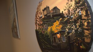 A circular view of a traditional European town with a prominent castle, a street lamp, and a bridge. - The Old Mill Bed & Breakfast (Biggar)