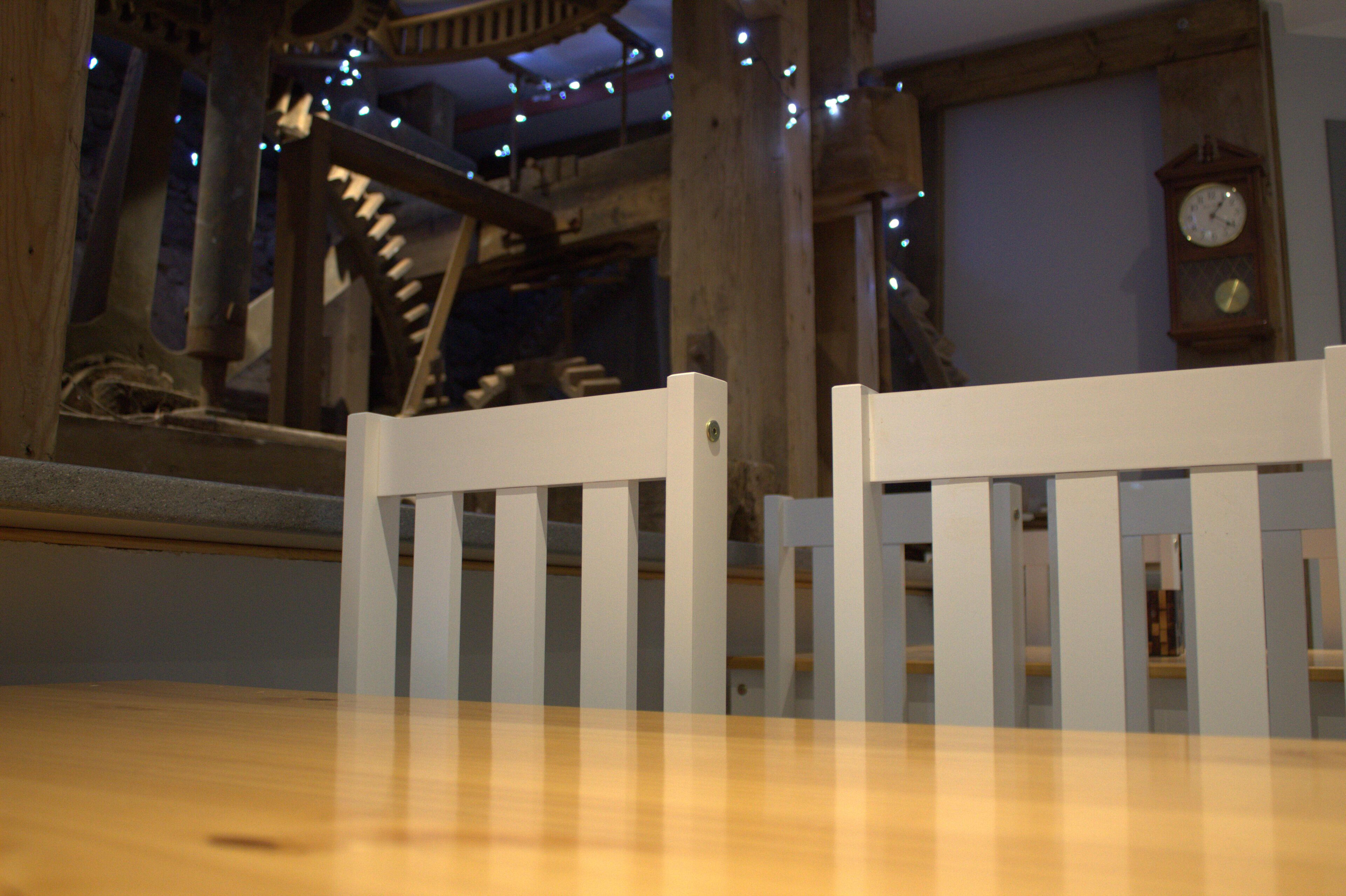 Une table en bois avec une chaise blanche placée devant.