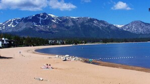 A beach with a mountain backdrop, clear skies, and a few people relaxing. - TKC0604 - Betty Ann's Place with Boat Dock (South Lake Tahoe)