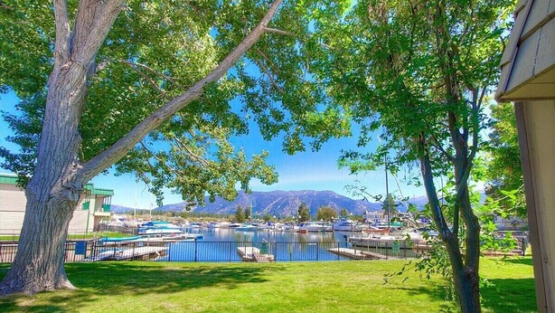 A marina with boats docked, surrounded by trees and a mountain backdrop. - TKC0604 - Betty Ann's Place with Boat Dock (South Lake Tahoe)