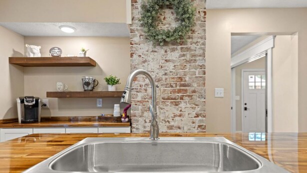 A kitchen with a large stainless steel sink, wooden countertops, and brick walls. - Shire-Southern-Comfort quiet 3-bedroom house w/WiFi and AC in heart of downtown  (Frankfort)