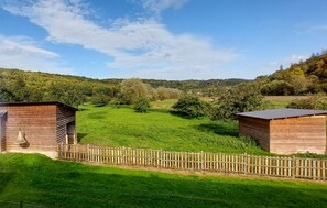 Escape to a serene countryside setting surrounded by lush green fields and rolling hills.