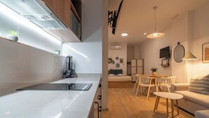 Une cuisine moderne dotée d’une cuisinière intégrée, de meubles de rangement en bois et d’un coin repas avec une table et des chaises.