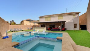 A backyard with a swimming pool, a covered patio, and a lawn. - Close to Airport, Stadium, and Strip. Villa with Amazing Pool and BBQ/Bar Area (Las Vegas)