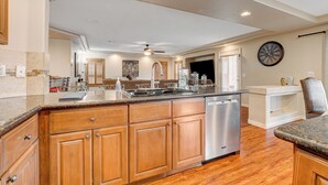 A spacious kitchen with wooden cabinets, a stainless steel dishwasher, and a large island.