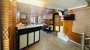 A hotel lobby with a reception desk, seating area, and a staircase leading to an upper floor. -  Barzam Lake View Resort (Srinagar)