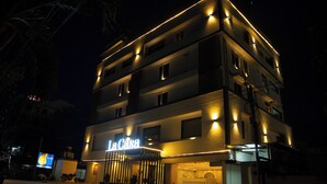 Un hôtel à plusieurs étages, doté d’une enseigne lumineuse bien visible sur laquelle on peut lire « La Casa ».