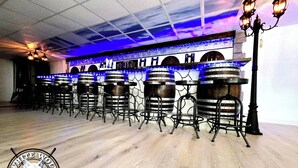 A bar area with wooden barrels, metal bar stools, and blue ambient lighting. - Charming 4-bedroom farmhouse in tranquil Reidsville with WiFi, AC, BAR (Reidsville)