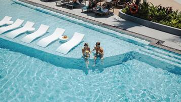 A swimming pool with lounge chairs and a lifebuoy.