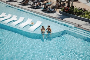 A swimming pool with lounge chairs and a lifebuoy. - Kora Beach Resort Phuket (Choeng Thale)