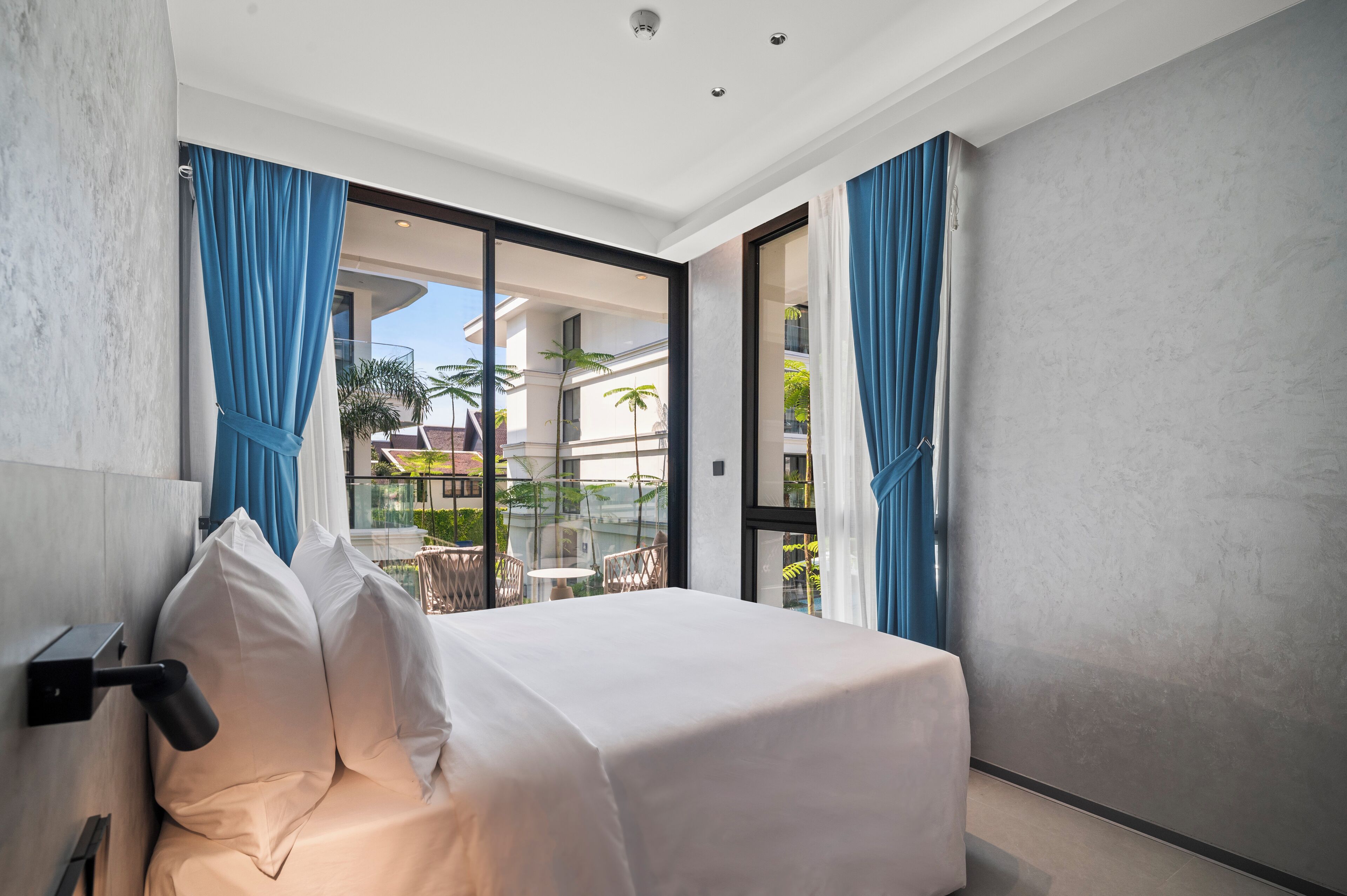 Ein Hotelzimmer mit Bett, Blick ins Freie und einem Balkon.