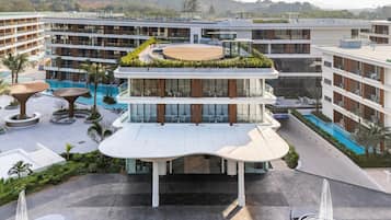 A multi-story hotel with a rooftop garden, a swimming pool, and a landscaped courtyard.