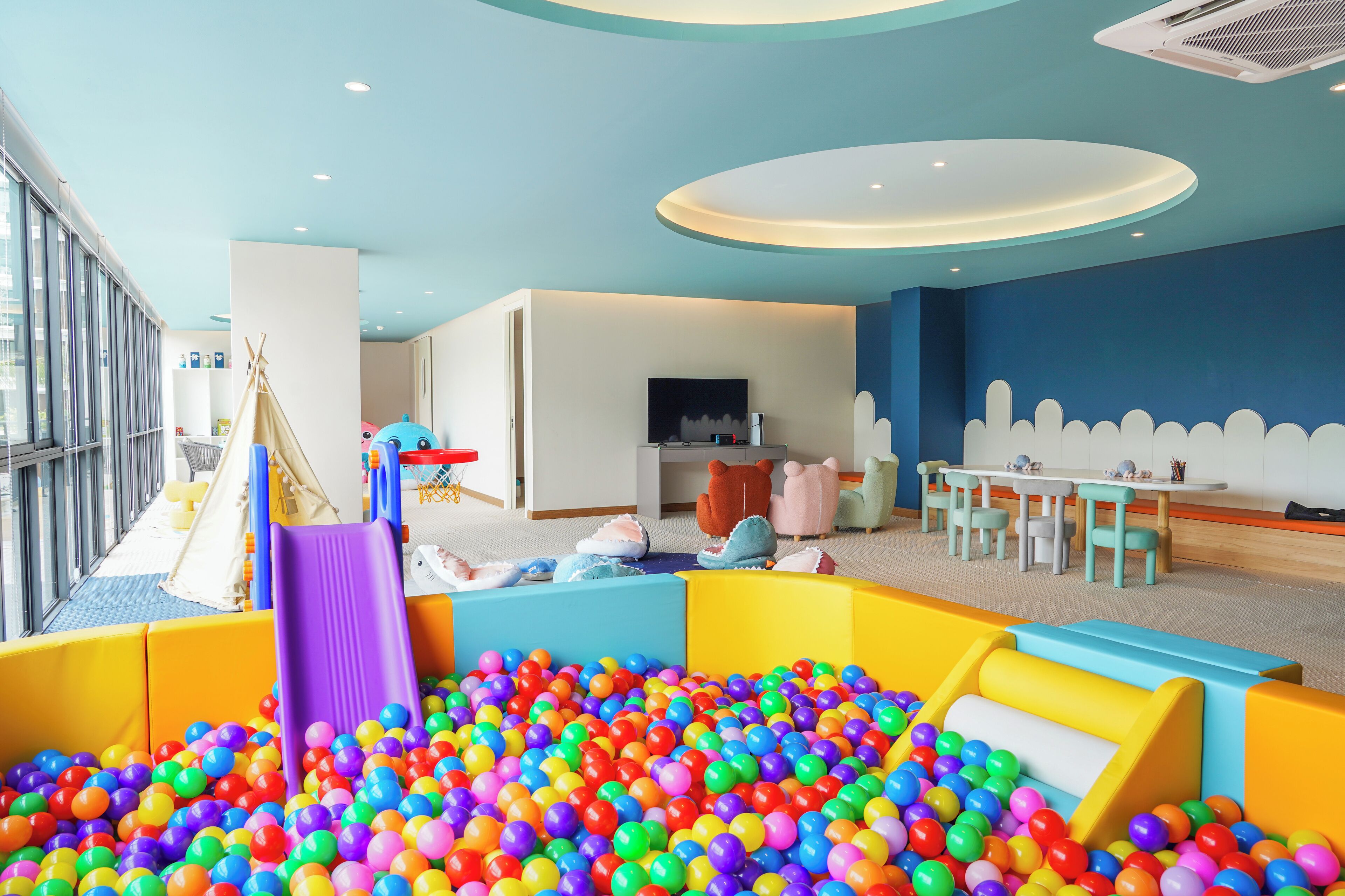A children's play area with a ball pit, a slide, and a tent.
