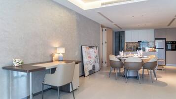 A modern kitchen with a dining area, featuring a central island, chairs, and a table set for dining.