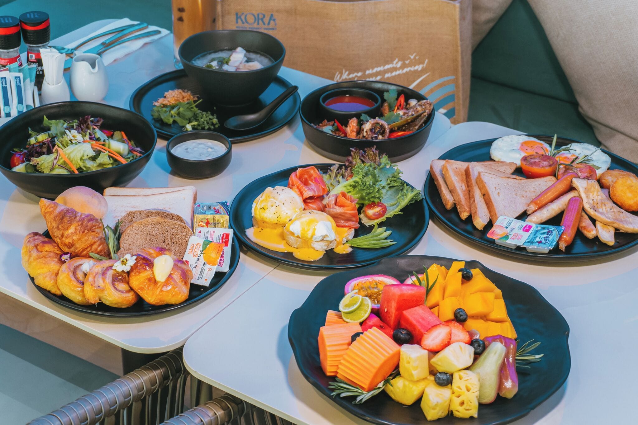 Un bufé de desayuno con diversos platos, incluyendo huevos, tostadas, bollería y fruta.