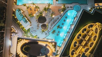 Relax by the infinity pool overlooking the surrounding landscape, surrounded by sun loungers and a serene garden.