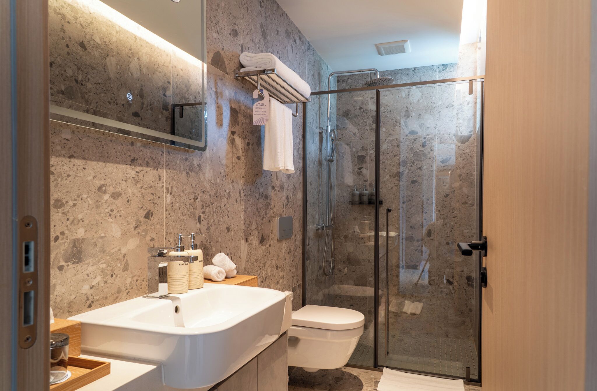 Ein modernes Badezimmer mit einem großen Waschbecken, einer Toilette und einer Duschkabine aus Glas.