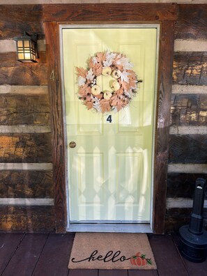 A yellow door with a wreath, a 'hello' doormat, and a number '4' on the door. - Cozy cabin in lovely Seneca Rocks WV with WiFi, smart TVs and jucuzzi tub  (Seneca Rocks)