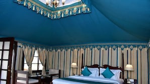 A large, tent-like room with a bed, two chairs, and a chandelier. - Arvana Resort & Spa Pushkar (Pushkar)