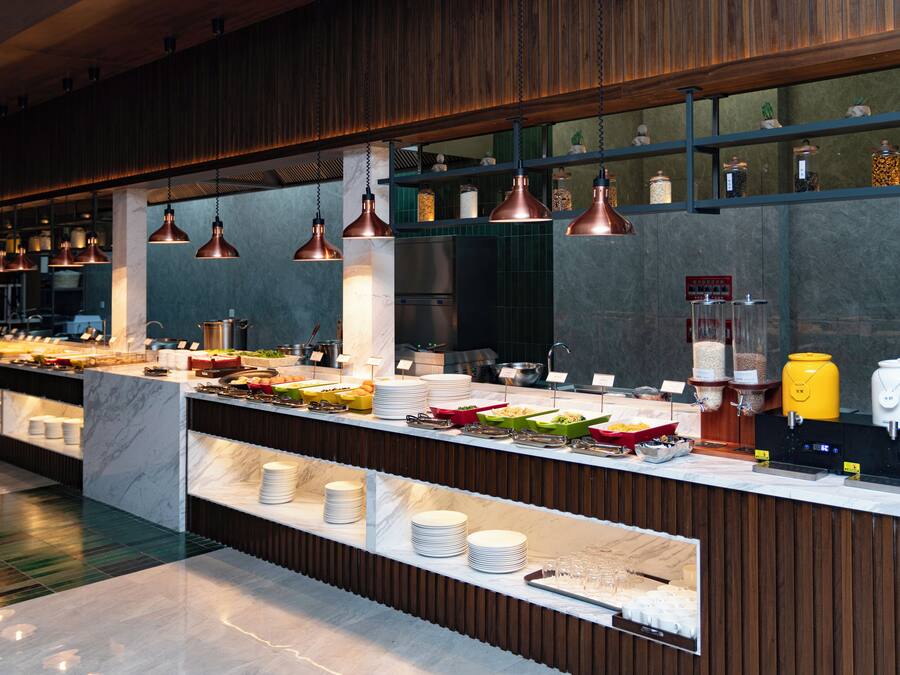 A buffet setup with various food items and utensils.