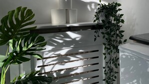 A room with a white radiator, a black ceiling fan, and a potted plant with green leaves. - Traditonal House - Etihad -Games Room-Free Parking (Manchester)