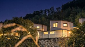 A modern two-story house with a stone retaining wall, multiple windows, and a balcony. - Gapyeong Gabom Kids Poolvilla Pension (Gapyeong)