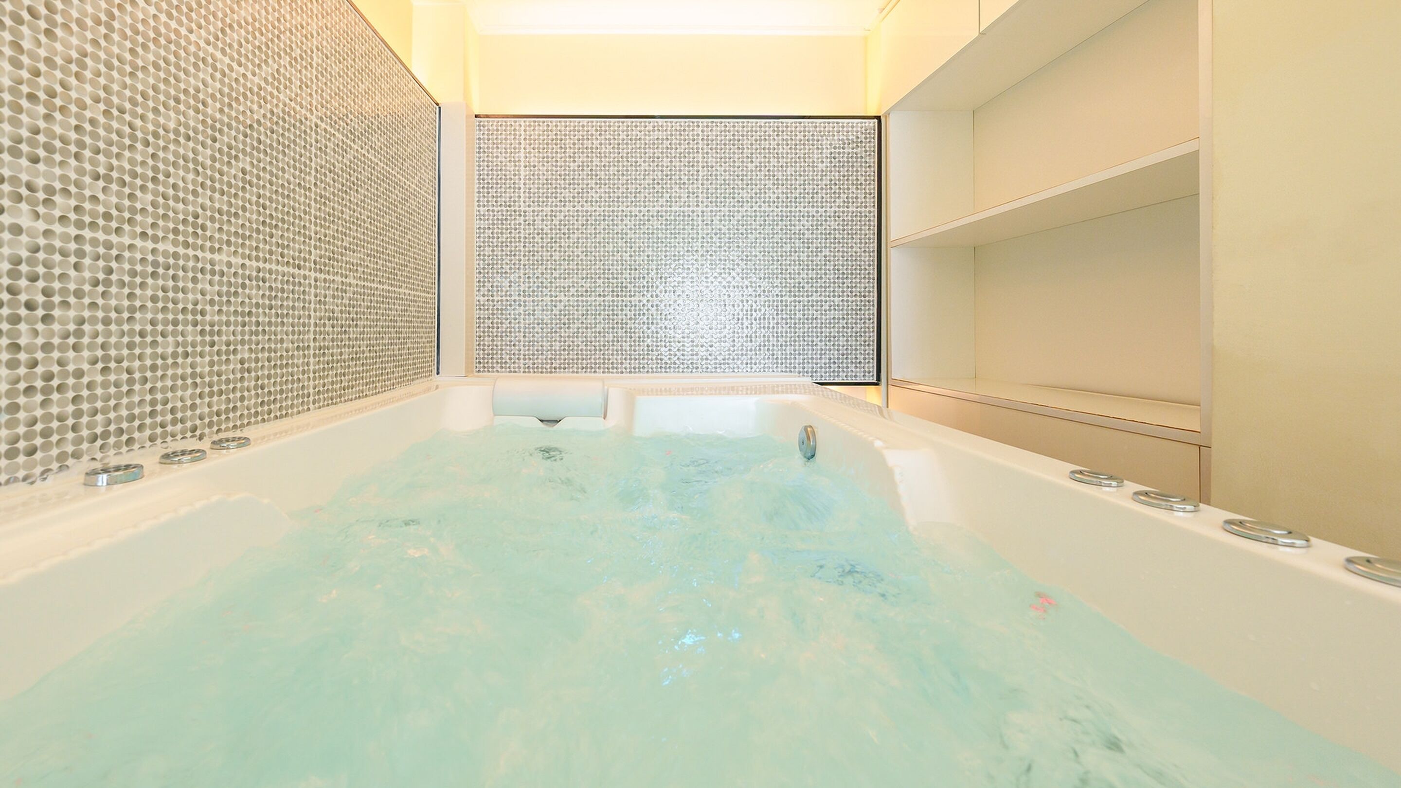 A modern bathroom with a freestanding bathtub, tiled walls, and a minimalist design.