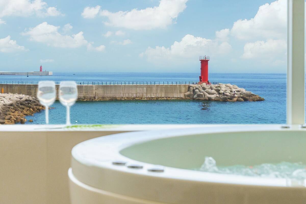 Un jacuzzi con vista al mar y un faro.
