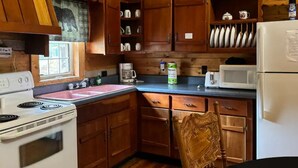 A wooden cabin kitchen with a stove, sink, and wooden cabinets. - Charming 3-bedroom 5 bed hottub cabin WiFi in scenic Seneca Rocks West Virginia (Seneca Rocks)