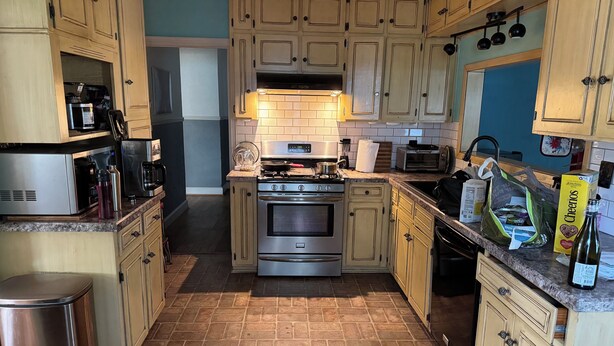 A kitchen with light wooden cabinets, stainless steel appliances, and a tiled floor. - Charming 3-bedroom house with WiFi, AC in lovely Wichita Falls (Wichita Falls)