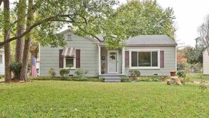 A two-story house with a front porch, a small garden, and a flag. - Charming 3-bedroom house with WiFi, AC in lovely Wichita Falls (Wichita Falls)