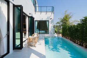 A modern building with a swimming pool, large windows, and outdoor seating. - Lyntara Pool Villa Nongkhai (Nong Khai)