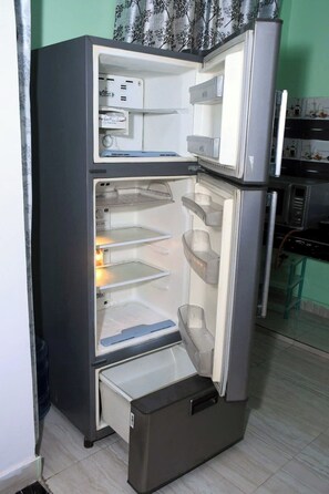 Kitchen features a compact refrigerator with a freezer compartment and main storage area.