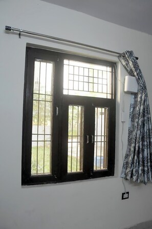 Enjoy the view from the large window with a central door and a patterned curtain.